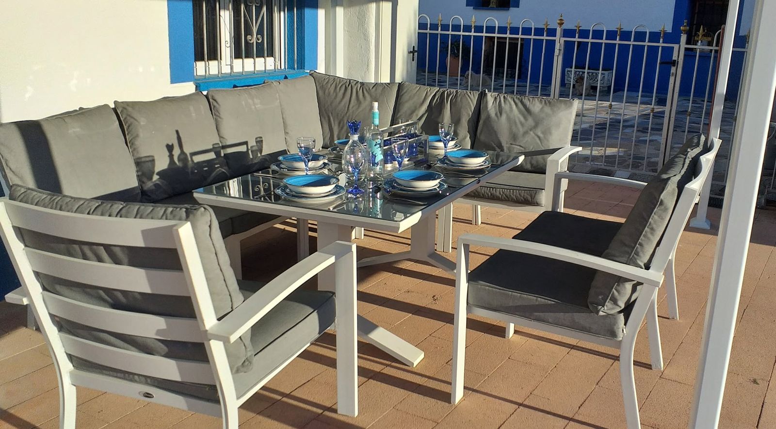 Villa terrace table set with blue plates and glasses