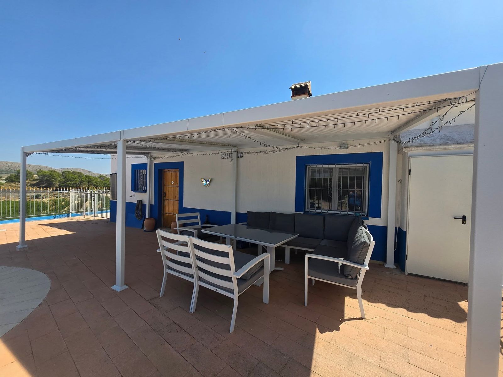 Casa Dorada villa with its covered terrace, blue trim and outdoor sofa set